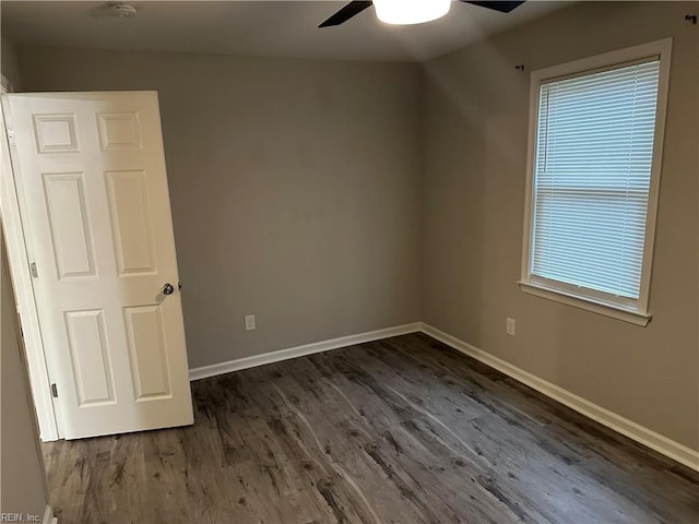 empty room with dark hardwood / wood-style floors and ceiling fan