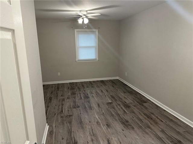 spare room with dark hardwood / wood-style flooring and ceiling fan