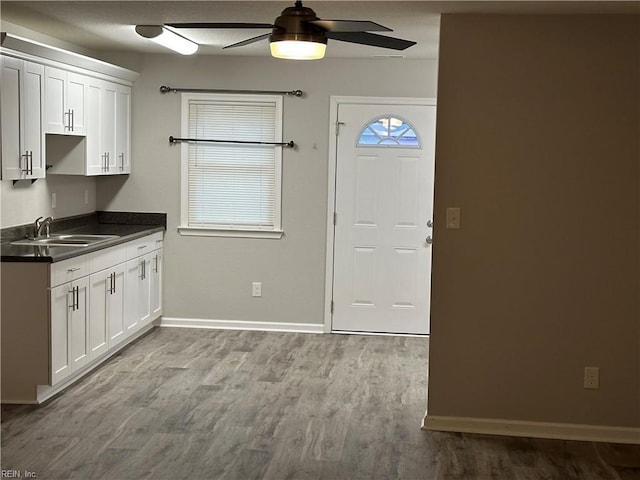 kitchen featuring white cabinetry, ceiling fan, sink, and light hardwood / wood-style flooring