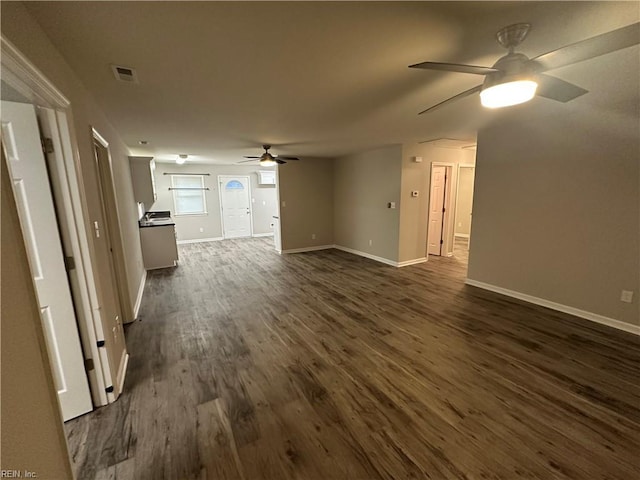 unfurnished living room with dark hardwood / wood-style flooring and ceiling fan