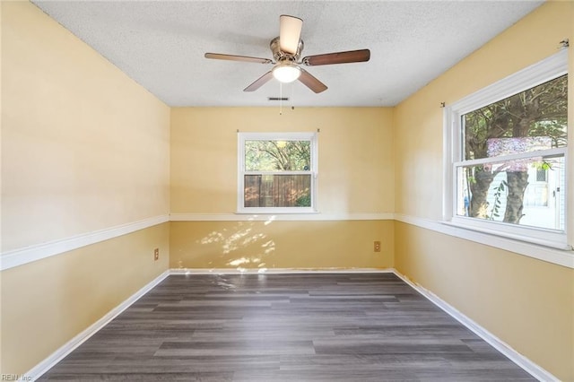 spare room with ceiling fan, dark wood-type flooring, and a textured ceiling