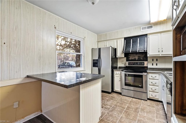 kitchen with a breakfast bar area, appliances with stainless steel finishes, white cabinetry, ventilation hood, and kitchen peninsula