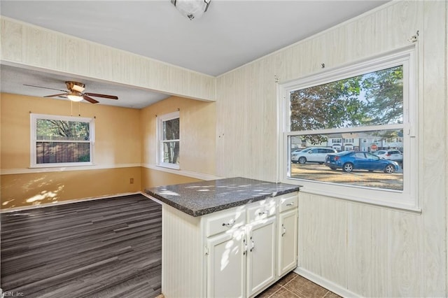 kitchen with ceiling fan, white cabinets, dark stone counters, and kitchen peninsula