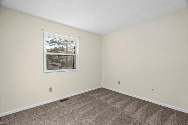 empty room with carpet floors and a textured ceiling