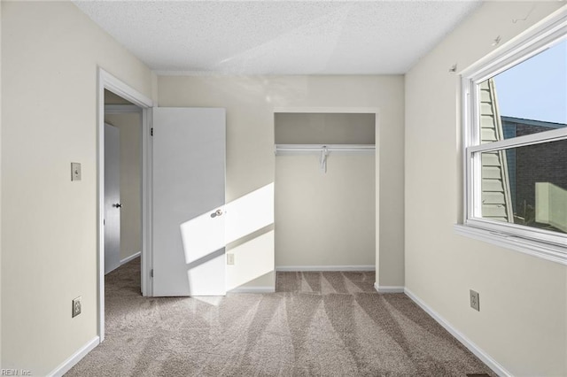 unfurnished bedroom with carpet floors, a textured ceiling, and a closet