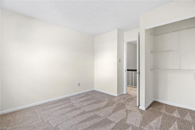 unfurnished bedroom featuring light carpet, a textured ceiling, and a closet