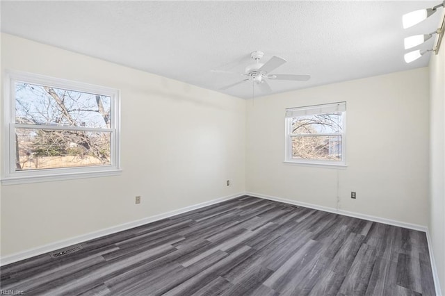 spare room with dark hardwood / wood-style flooring, a textured ceiling, and ceiling fan