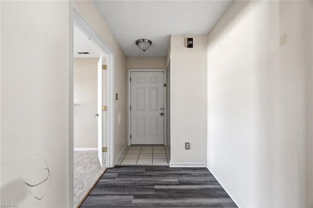 corridor featuring dark hardwood / wood-style floors and a textured ceiling