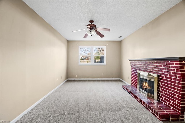 unfurnished living room with ceiling fan, a fireplace, carpet floors, and a textured ceiling