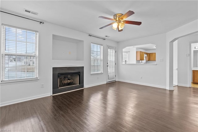 unfurnished living room with ceiling fan and dark hardwood / wood-style flooring