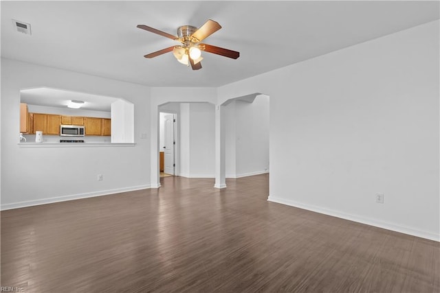 unfurnished living room with dark hardwood / wood-style floors and ceiling fan