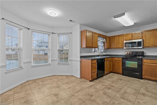 kitchen with sink, light tile patterned floors, and black appliances