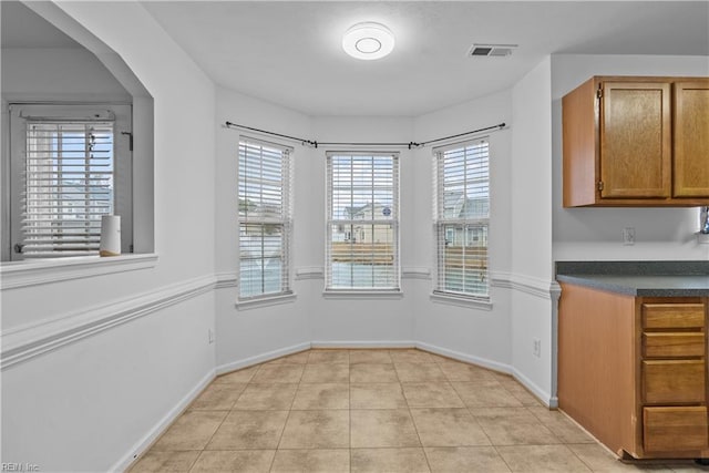 unfurnished dining area featuring light tile patterned floors