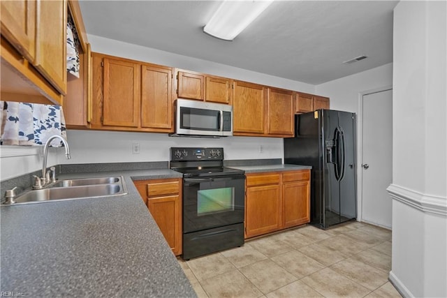 kitchen featuring sink, black appliances, and light tile patterned flooring