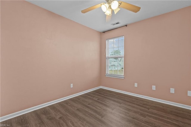 empty room with ceiling fan and dark hardwood / wood-style flooring