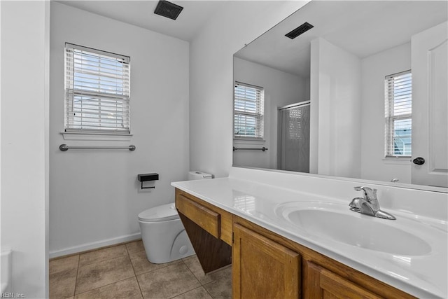 bathroom featuring a wealth of natural light, tile patterned floors, toilet, and walk in shower