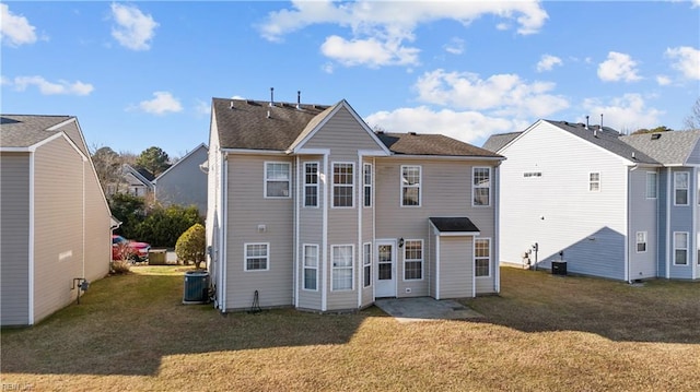 back of property featuring central AC and a lawn