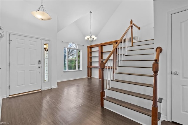 foyer featuring an inviting chandelier, high vaulted ceiling, and dark hardwood / wood-style floors