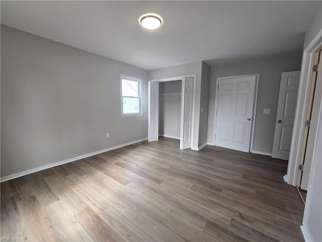 unfurnished bedroom featuring dark wood-type flooring and a closet