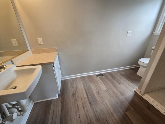 bathroom featuring toilet, sink, and hardwood / wood-style floors