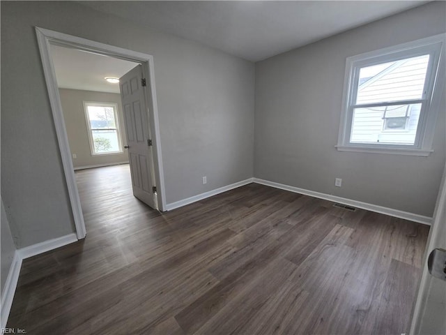 unfurnished room with dark hardwood / wood-style flooring