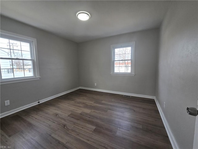 empty room with dark hardwood / wood-style floors