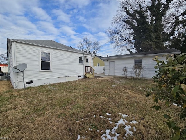 rear view of property featuring a lawn