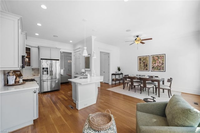 kitchen featuring sink, decorative light fixtures, a center island with sink, appliances with stainless steel finishes, and dark hardwood / wood-style flooring