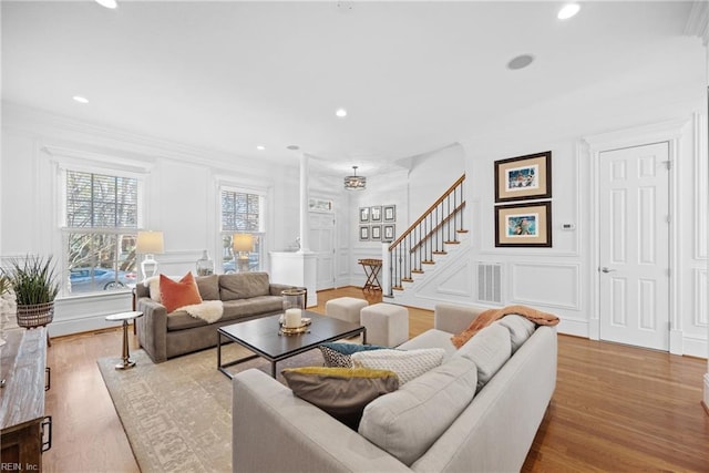 living room with crown molding and light wood-type flooring