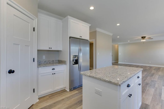 kitchen featuring white cabinetry, light stone countertops, a center island, and stainless steel fridge with ice dispenser