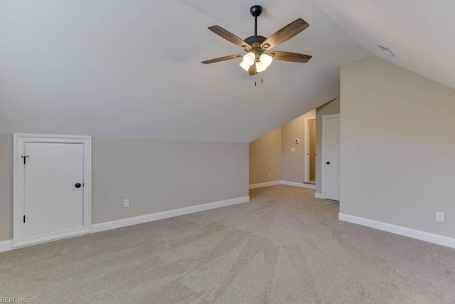 additional living space with vaulted ceiling, light carpet, and ceiling fan