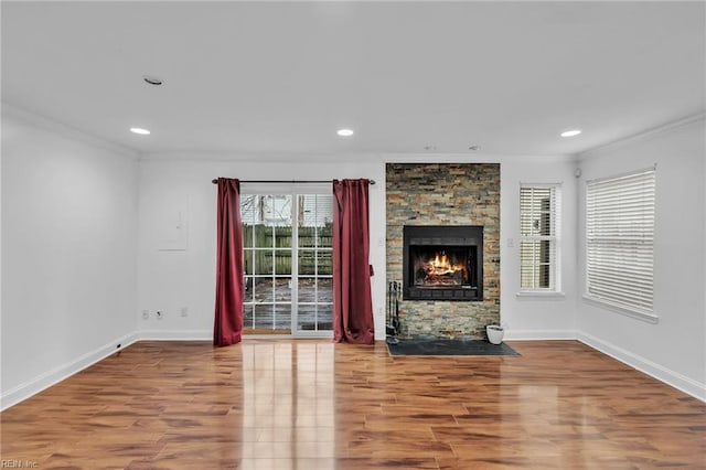 unfurnished living room with ornamental molding, wood-type flooring, and a fireplace