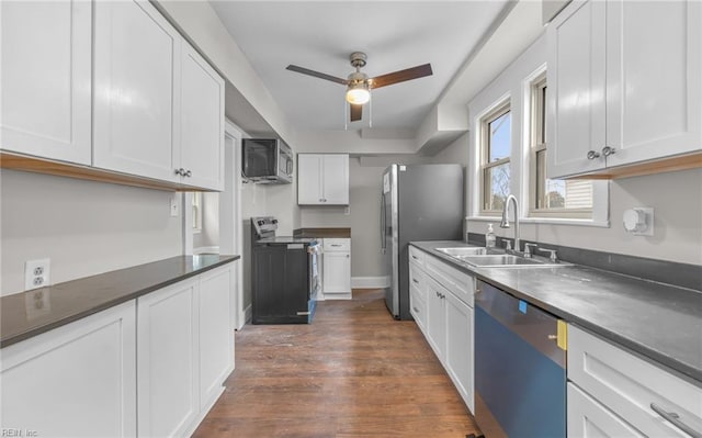 kitchen with dark hardwood / wood-style flooring, sink, stainless steel appliances, and white cabinets