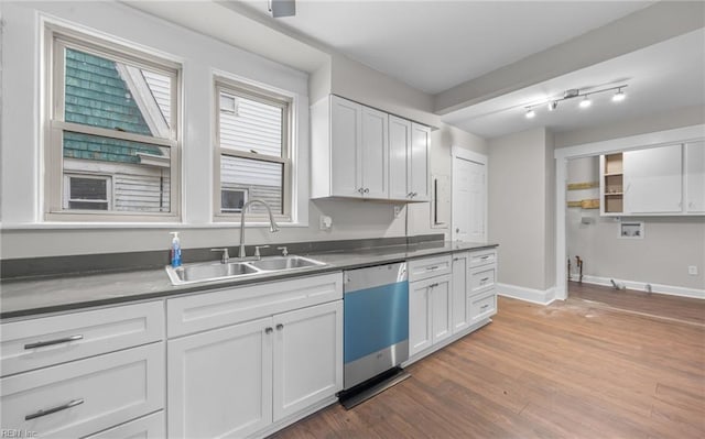 kitchen featuring dark wood finished floors, dishwasher, dark countertops, white cabinetry, and a sink