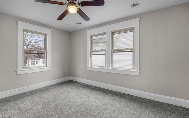 empty room with baseboards, visible vents, and carpet flooring