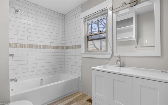 bathroom with tub / shower combination, wood finished floors, and vanity