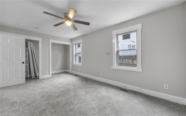 unfurnished bedroom with multiple windows, a closet, ceiling fan, and carpet