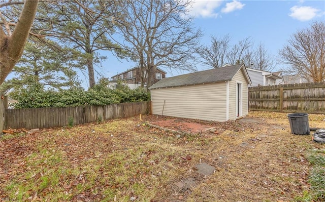 view of yard featuring an outbuilding, a fenced backyard, and a storage shed