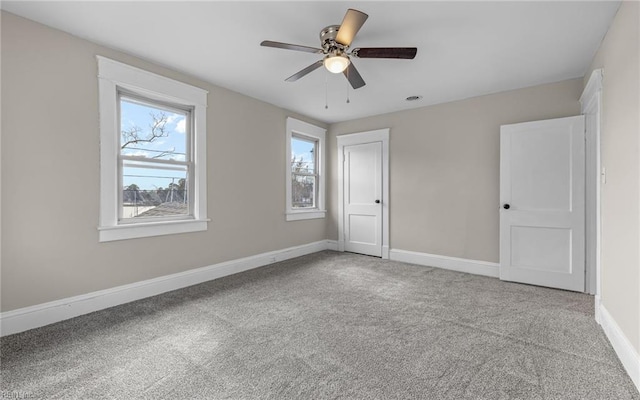 spare room with light carpet, baseboards, and a ceiling fan