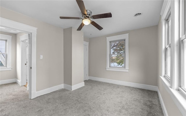 unfurnished bedroom featuring visible vents, light carpet, and multiple windows