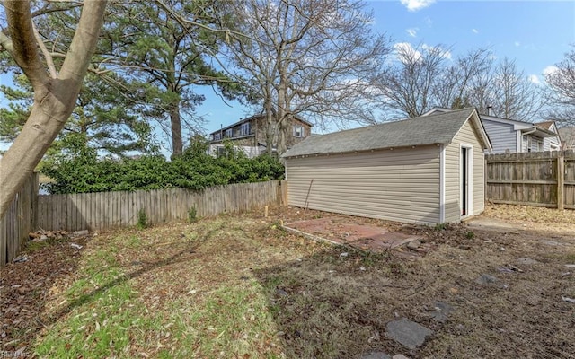 view of yard with an outbuilding, a fenced backyard, and a storage shed