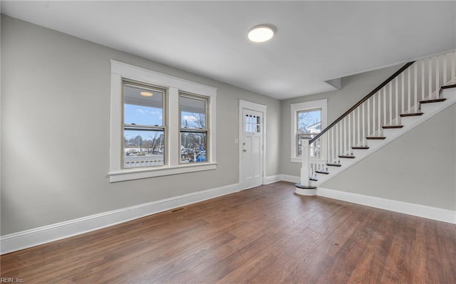 foyer with stairway, wood finished floors, and baseboards