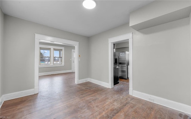 empty room featuring baseboards and wood finished floors