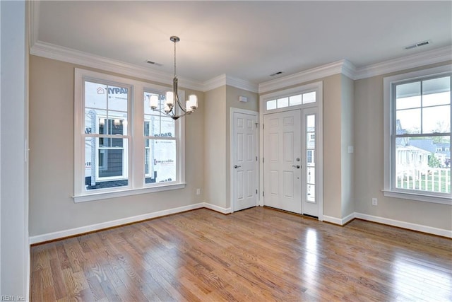 foyer entrance featuring visible vents, a notable chandelier, wood finished floors, and a healthy amount of sunlight