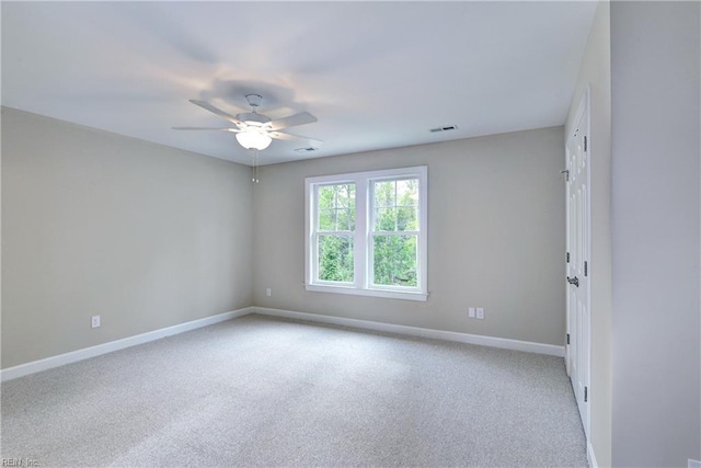 carpeted spare room featuring visible vents, ceiling fan, and baseboards