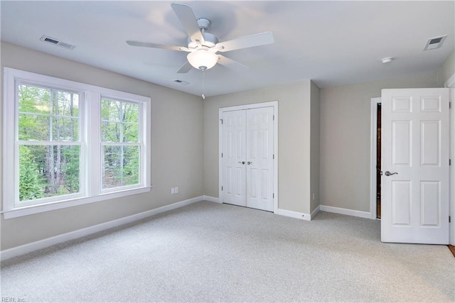 unfurnished bedroom featuring baseboards, visible vents, light carpet, and a closet