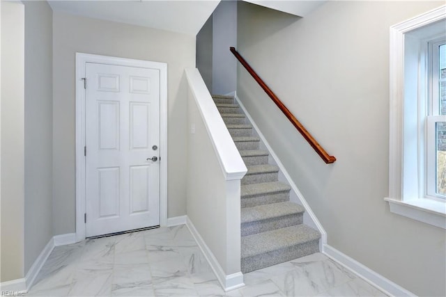 staircase with marble finish floor and baseboards