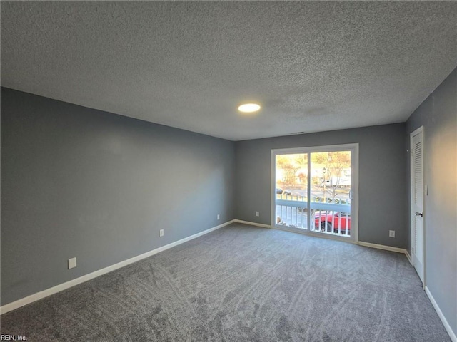 carpeted spare room featuring a textured ceiling