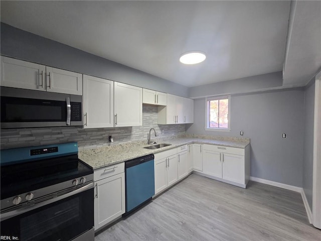 kitchen featuring sink, decorative backsplash, stainless steel appliances, and white cabinets