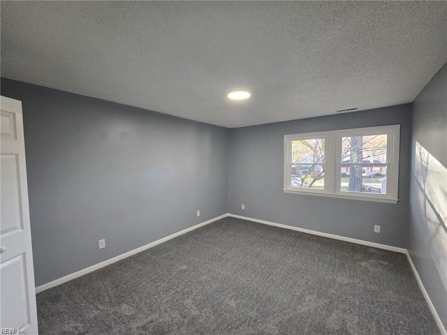 carpeted empty room featuring a textured ceiling